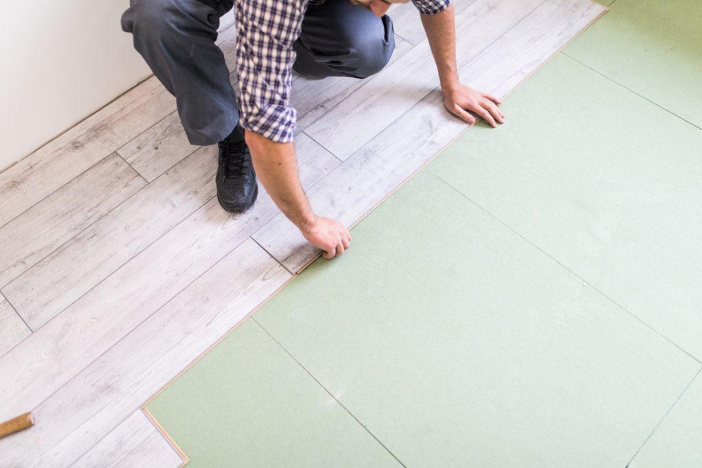 worker-processing-floor-with-bright-laminated-flooring-boards worker